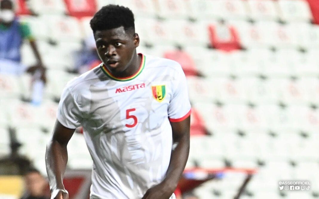 Jeune footballeur guinéen portant maillot blanc avec numéro 5.