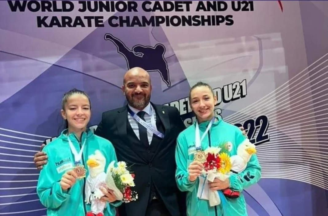 Deux jeunes judokas algériennes avec leur entraîneur après leur victoire.