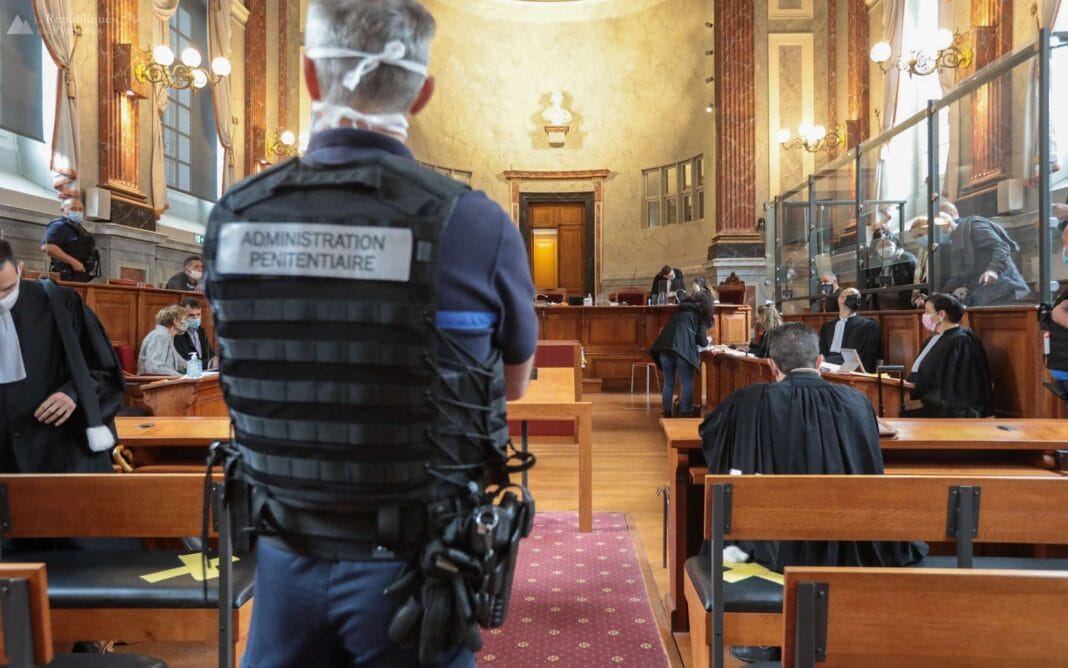 Agent de prison en uniforme dans une salle d'audience judiciaire.