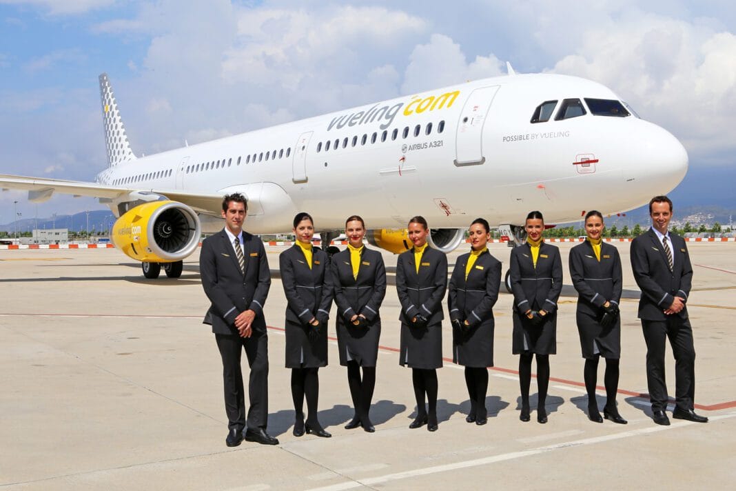 Équipage de Vueling Airlines devant un avion à l'aéroport.