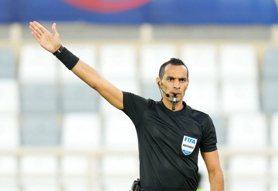 Arbitre Mustapha Ghorbal dirige un match de football international.
