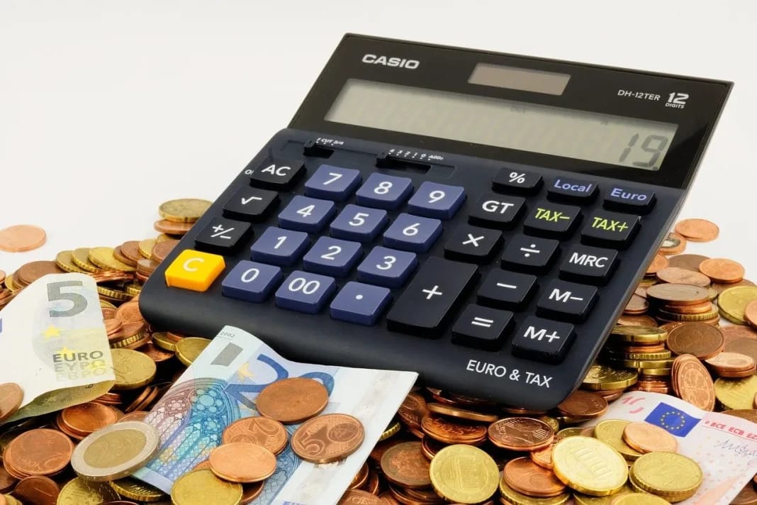 Taux de change: voici les cotations du dinar aux marchés officiel et parallèle ce 5 novembre Calculatrice avec monnaies en euros et dinar sur une table de pièces.