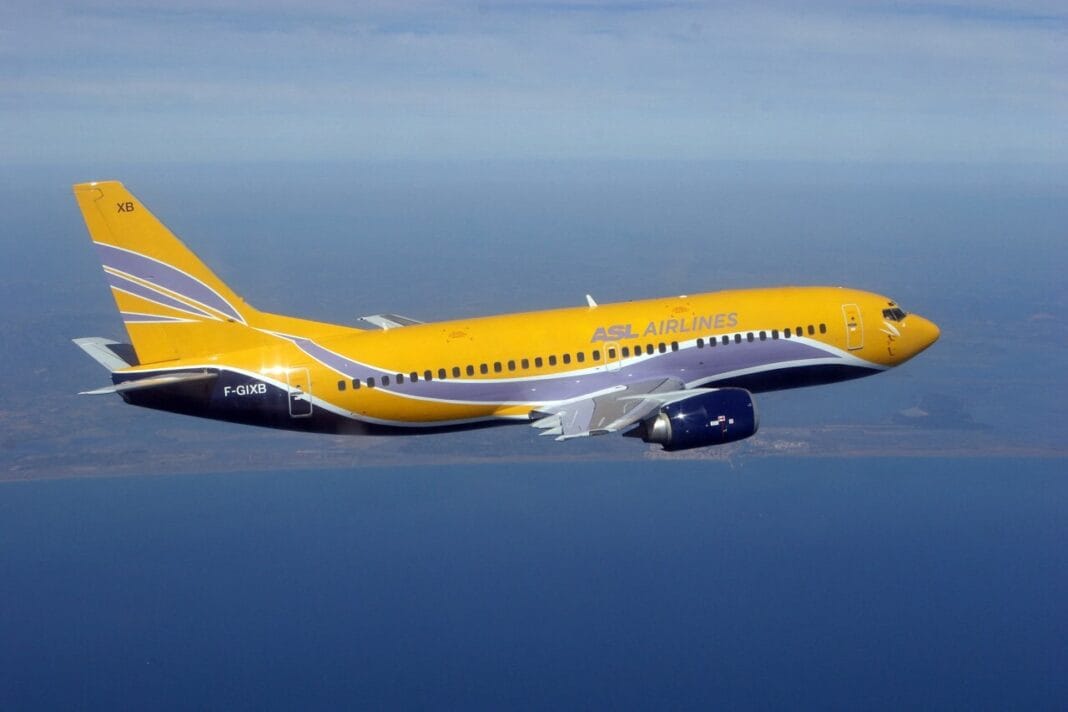Avion jaune d'ASL Airlines en vol au-dessus de l'océan.