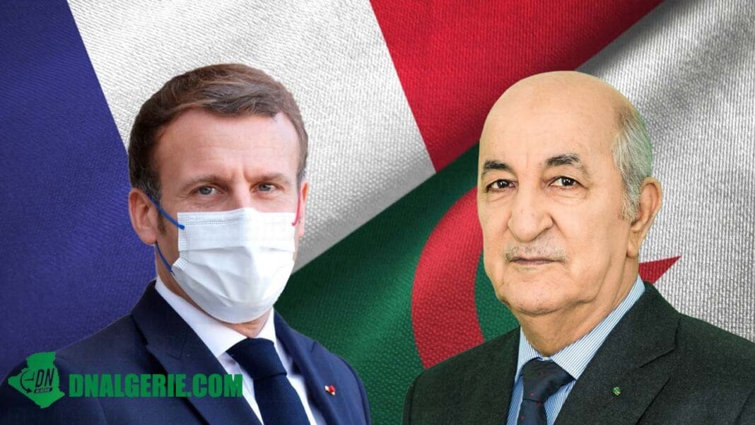 Deux hommes en costume avec masques, fond de drapeaux français et algérien.