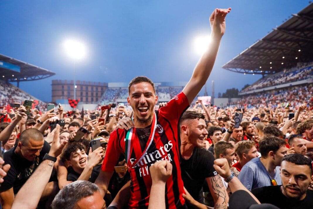 Joueur du Milan AC célébrant avec des fans lors d'un match.