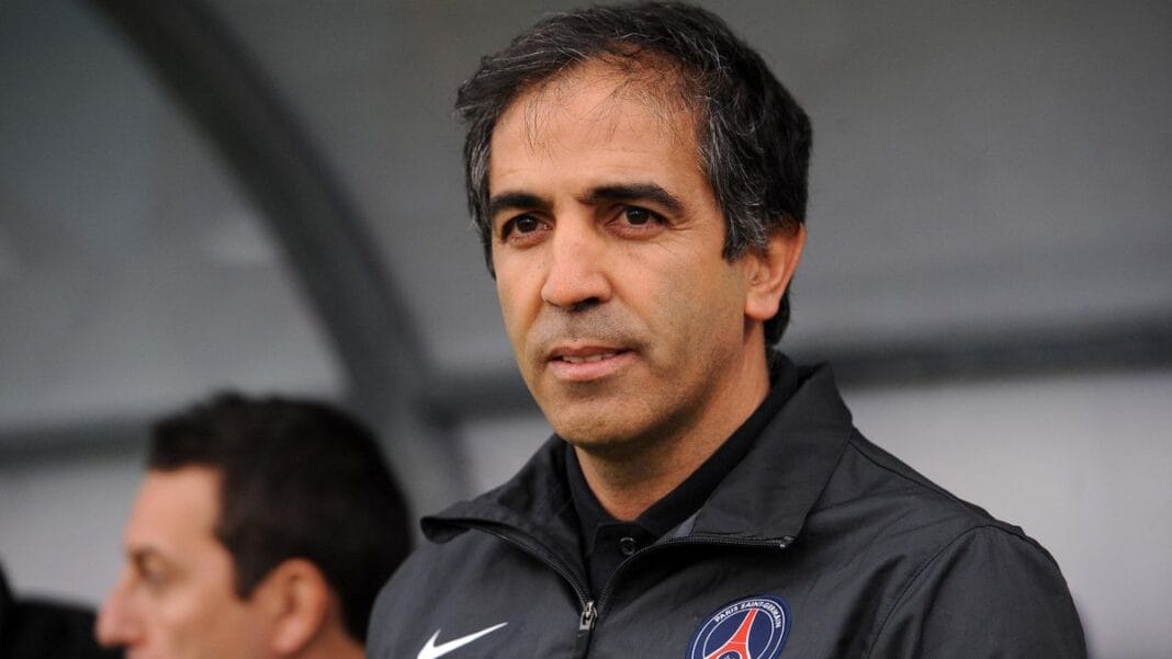 Homme en veste Nike avec logo PSG, portrait sérieux.