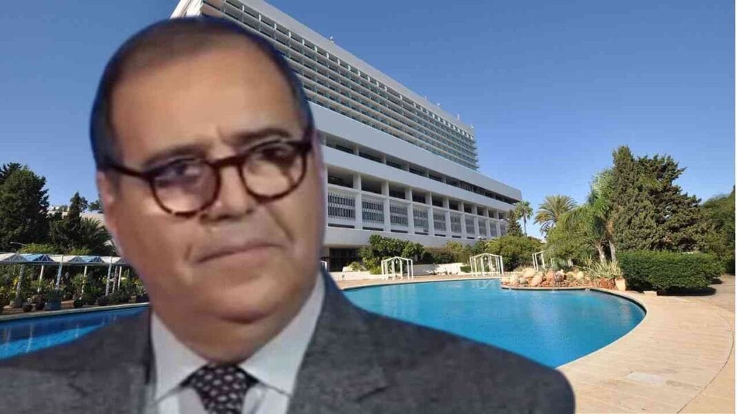 Portrait de Lamri Abdelkader devant un hôtel de luxe à Alger.