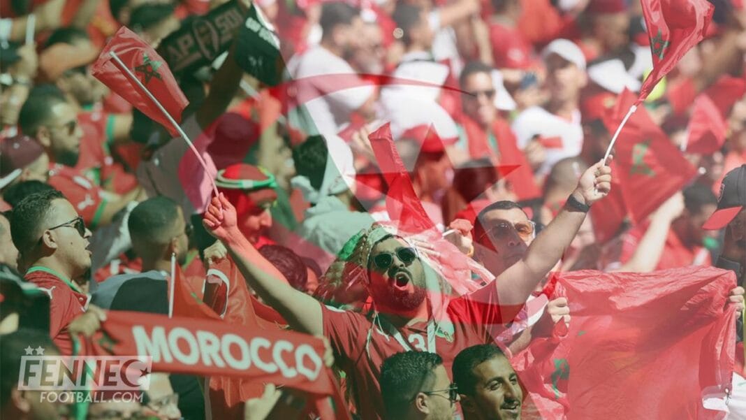 Supporters marocains en fête avec drapeaux et banderoles lors d'un match de football.
