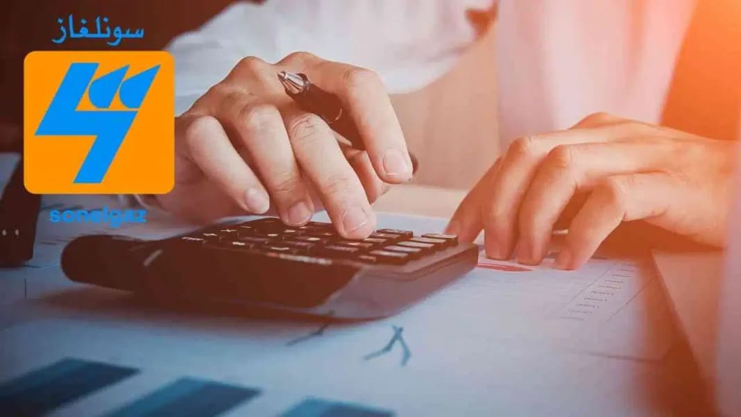Personne utilisant une calculatrice pour payer une facture Sonelgaz.
