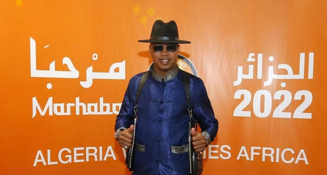 Homme portant un costume bleu, chapeau noir et lunettes de soleil lors de l'événement Marhaba 2022.