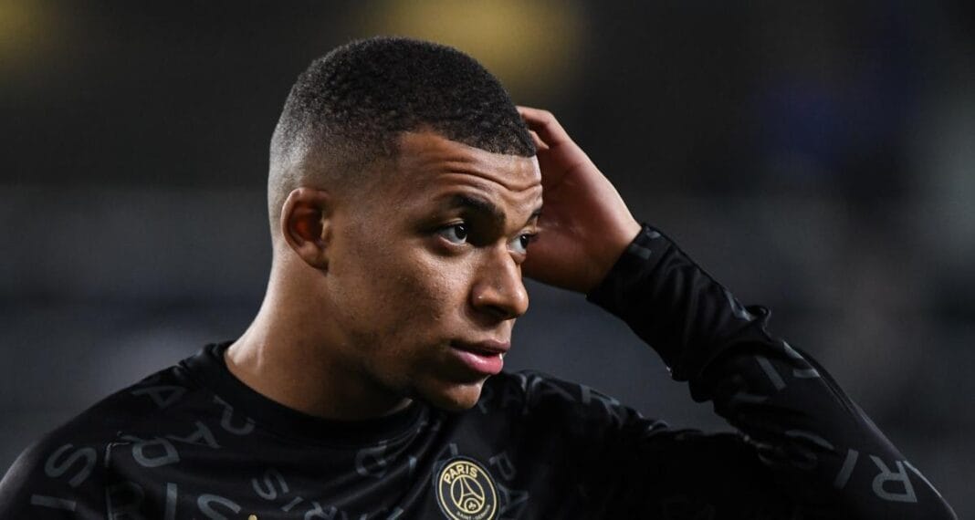 Kylian Mbappé avec expression préoccupée sur le terrain.