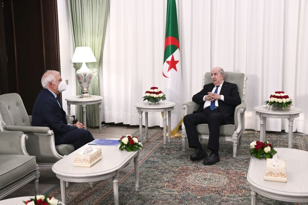 Corruption et blanchiment d’argent : l’UE et l’Algérie s’allient dans la lutte. Deux hommes en réunion officielle dans un salon élégant avec drapeau algérien.