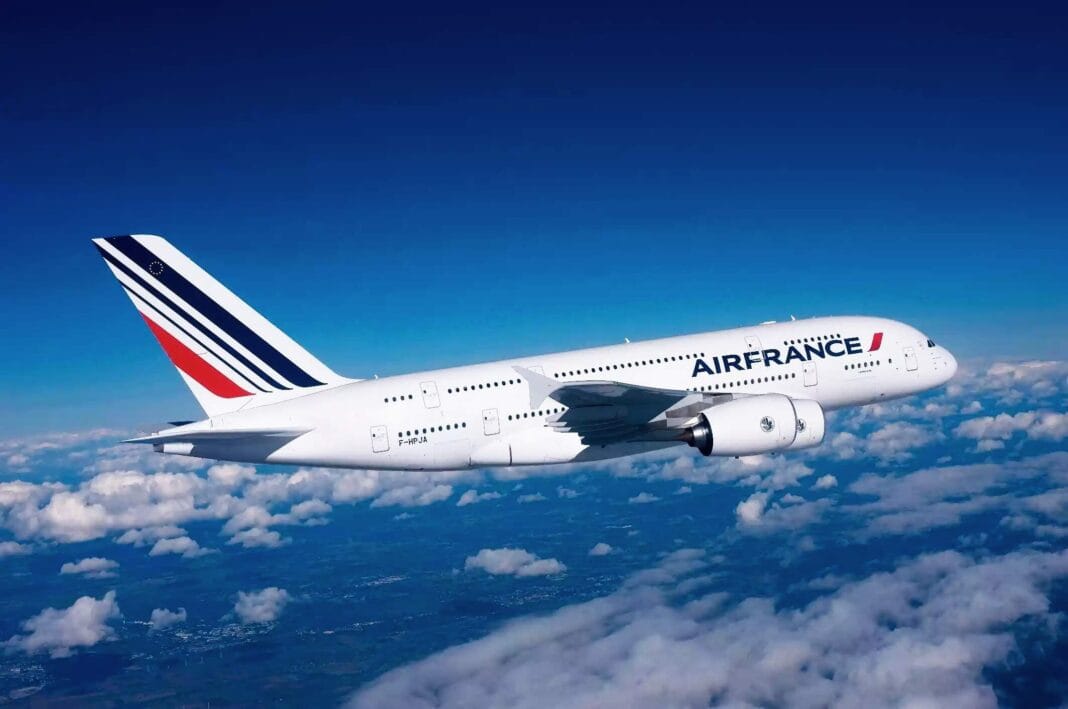 Avion Air France survolant les nuages en ciel clair.