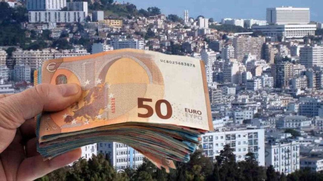 Foule de billets de 50 euros dans la main avec ville en arrière-plan.