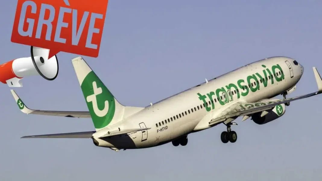 Avion Transavia en vol avec panneau de grève en arrière-plan.
