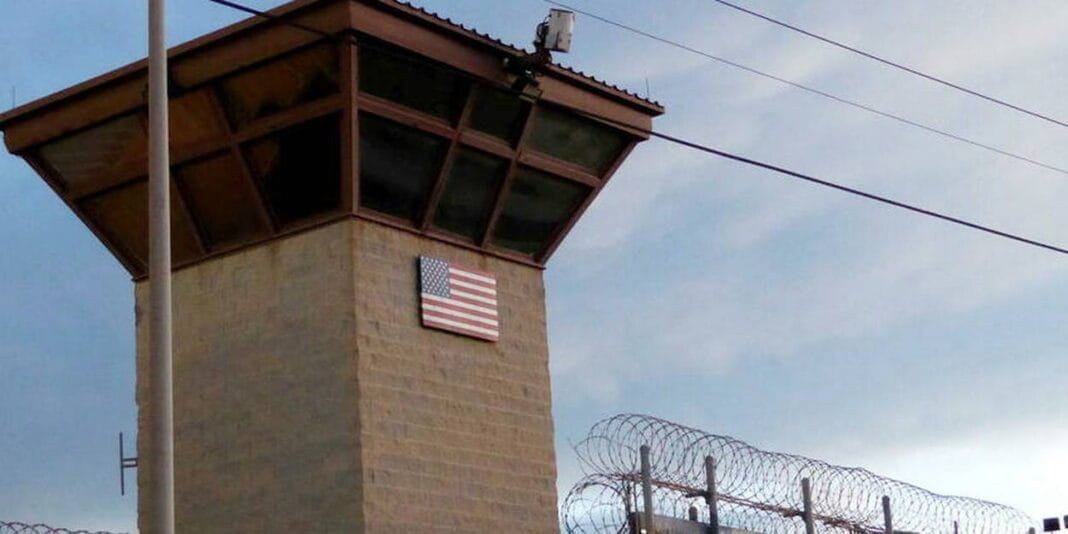 USA : un Algérien retrouve la liberté après 20 ans de détention Tour de garde avec drapeau américain et barbelés.