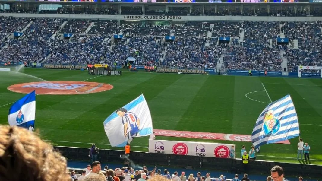 Vue du stade Dragao avec supporters et drapeaux en avant-plan.