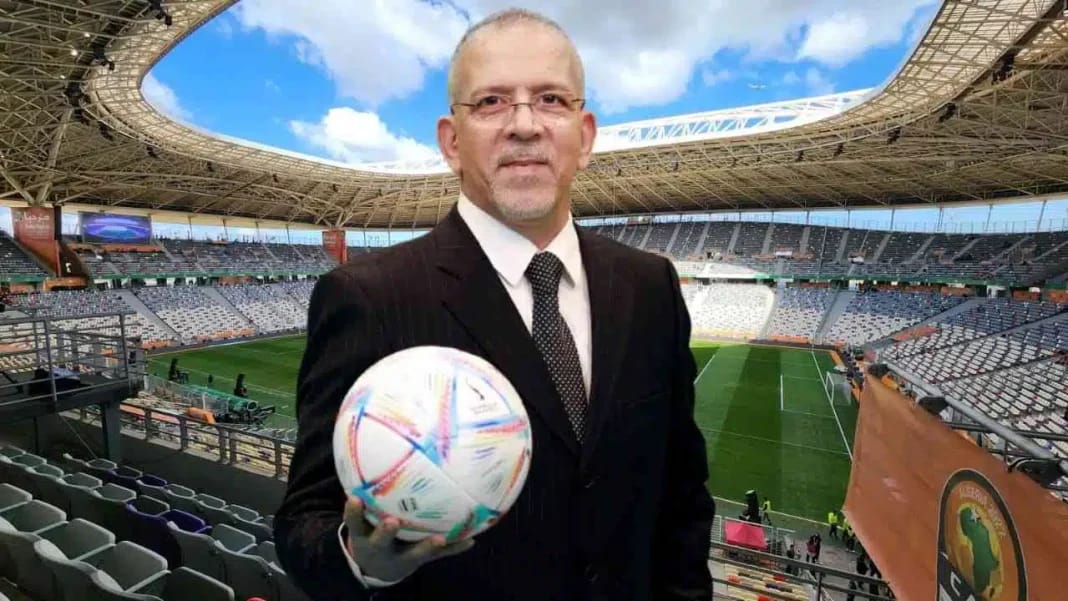 Hafid Derradji avec un ballon de football dans un stade vide.