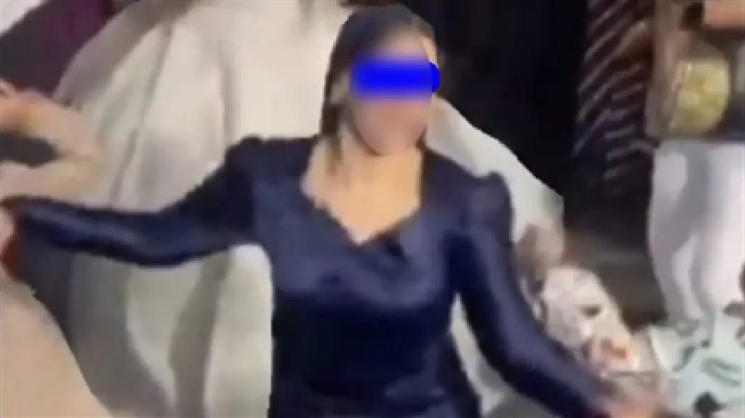 Jeune fille en robe bleue qui danse avec énergie lors d'une fête.
