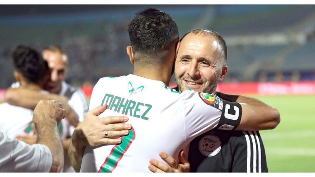 Riyad Mahrez et l'entraîneur se félicitent après un match de football.