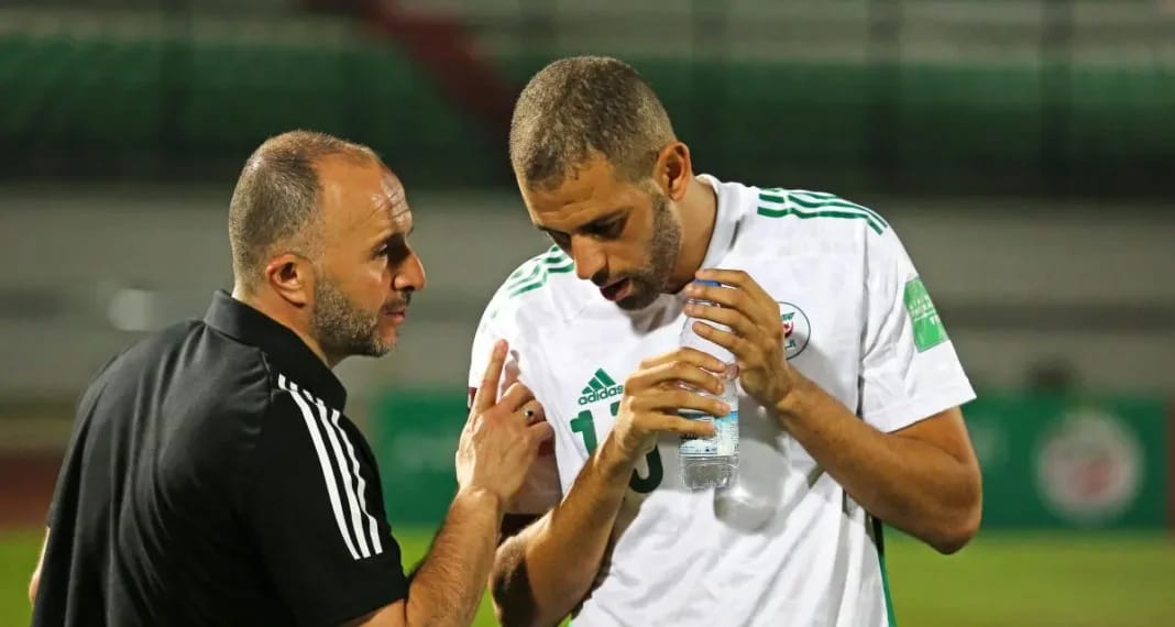 Youcef Belaili et Islam Slimani en discussion lors d'un match de football.