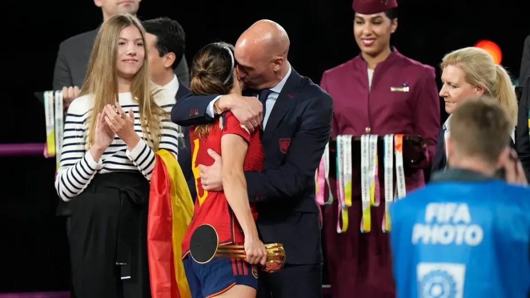 Un homme remet une médaille à une jeune athlète lors d'une cérémonie sportive.