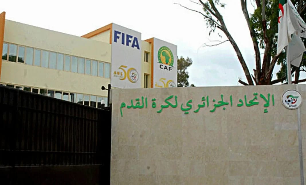 Bâtiment de la CAF avec logo FIFA et panneau en arabe.