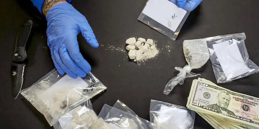 En tant qu’unité familiale, ils s’adonnent à la vente de drogue tout en faisant parvenir les bénéfices en Algérie Main portant des gants bleus manipulant de la drogue en sachets.