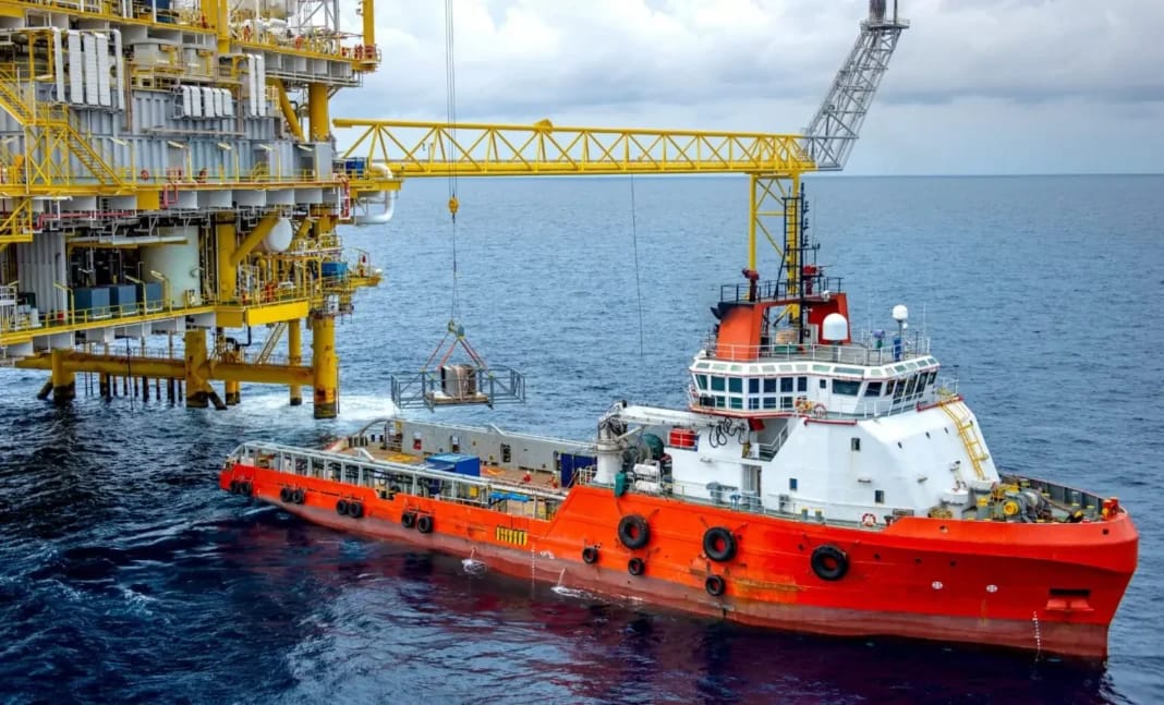 Remorqueur en mer près d'une plateforme pétrolière en mer.