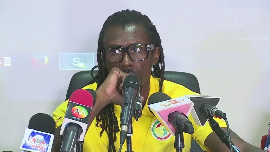 Défaite contre l’Algérie : « C’est un cycle qui s’arrête », Aliou Cissé Aliou Cissé parle lors d'une conférence avec microphones.