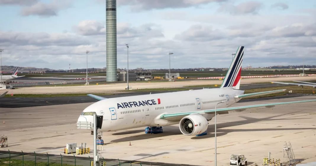 Air France : Découvrez les options de billets d’avion pour un voyage adapté à vos besoins Avion Air France stationné à l'aéroport avec terminal en arrière-plan.