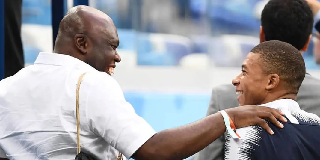 Père et fils Mbappé partageant un moment amusant et complice.