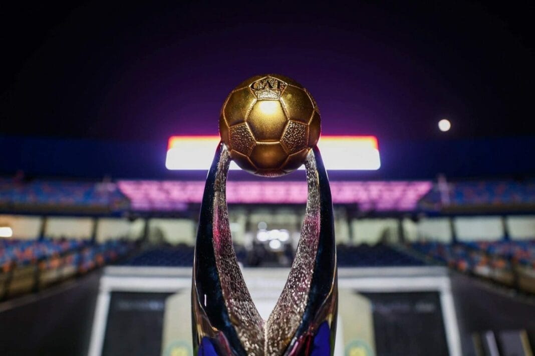 Trophée de football en or brillant sur fond de stade nocturne.