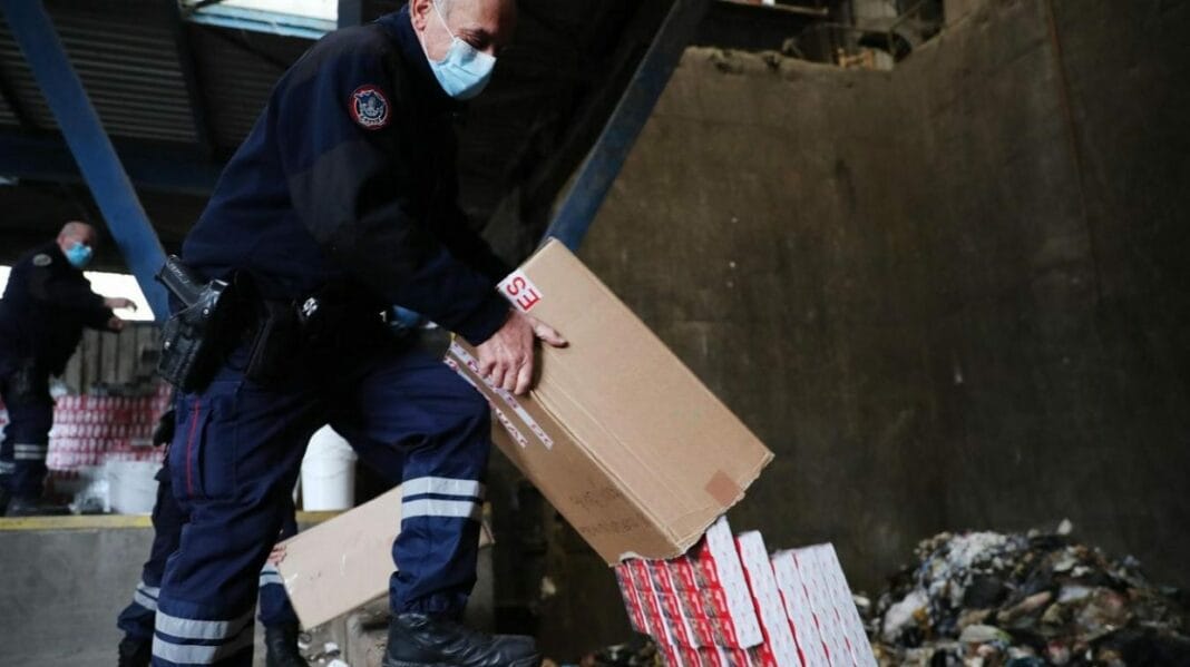 Agents de police inspectant des colis de tabac illégal.