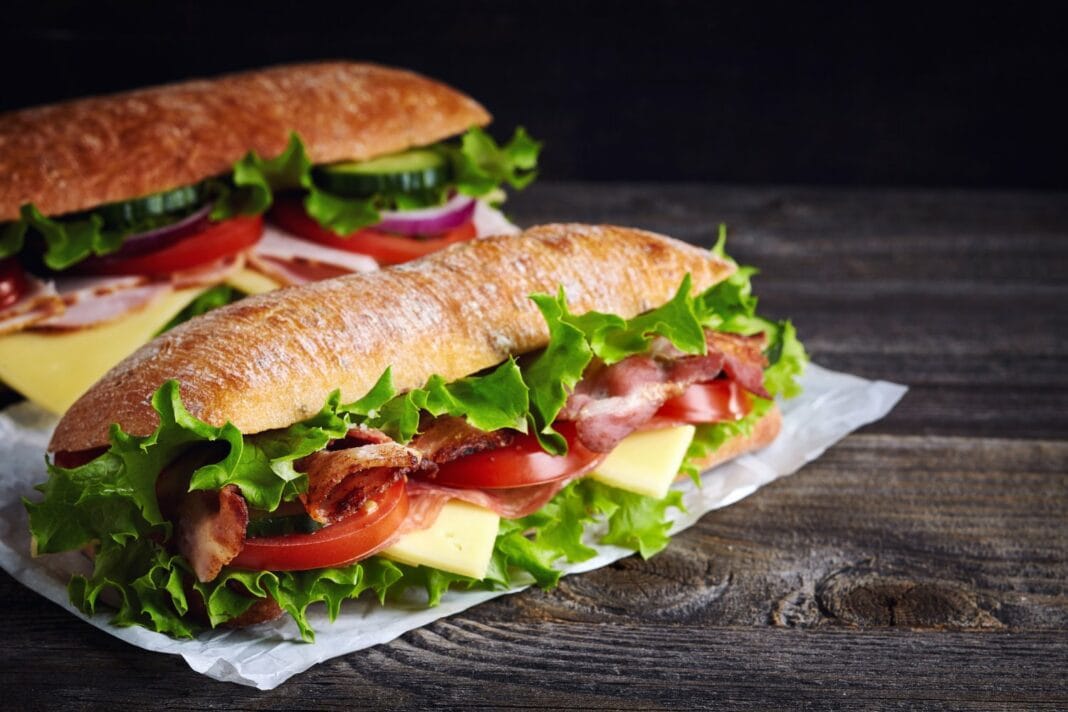 Sandwich avec légumes, viande et fromage sur pain croustillant.