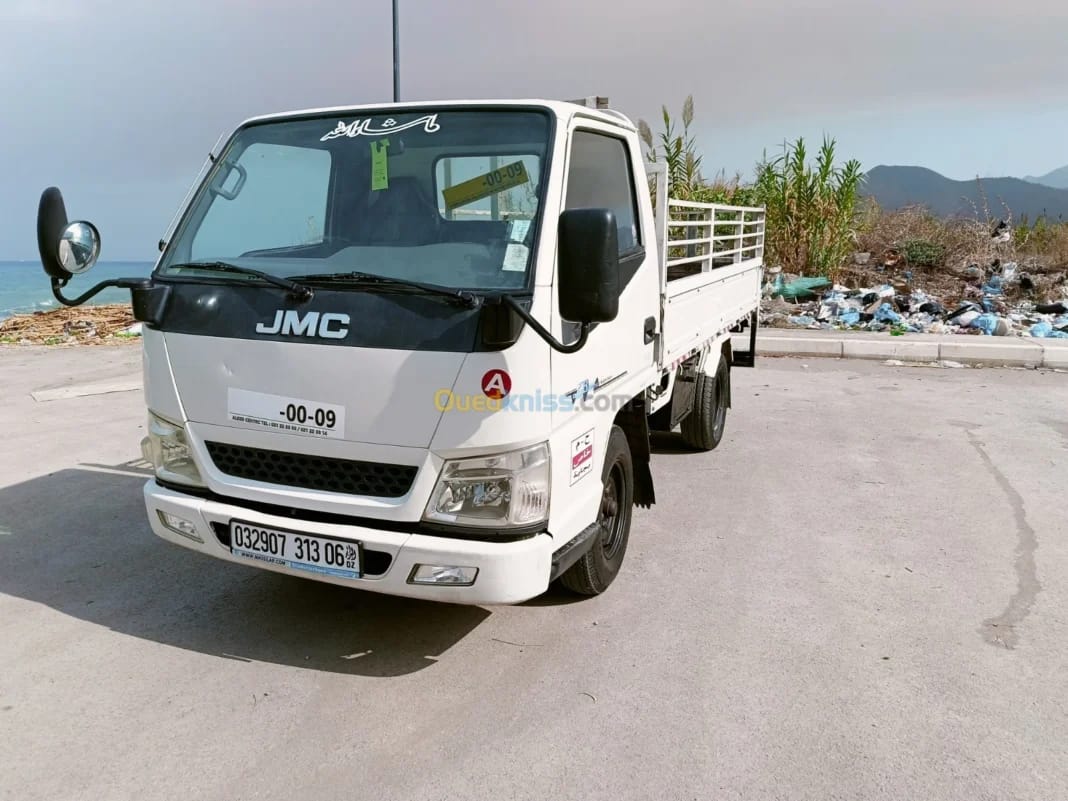 Camion JMC blanc stationné près de la mer en Algérie.
