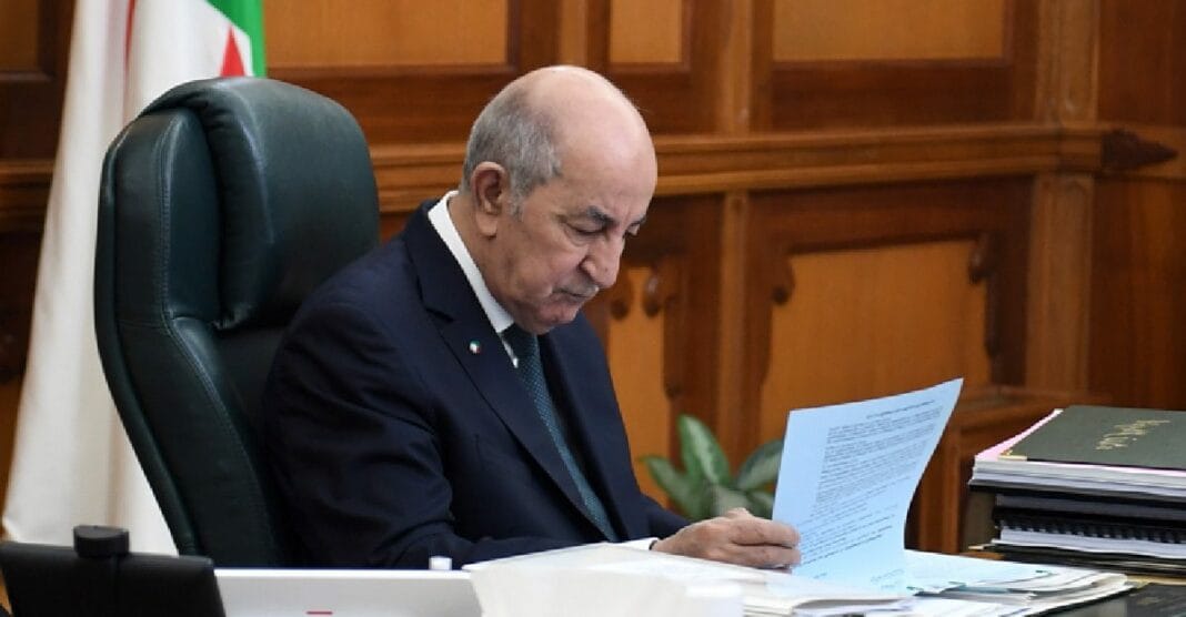 Tebboune, président algérien, examine un document officiel dans son bureau.