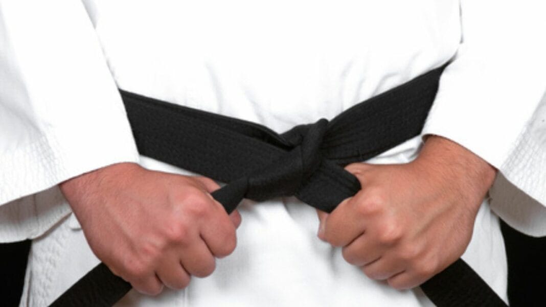 Dihia Chikhi en kimono de karaté avec ceinture noire.