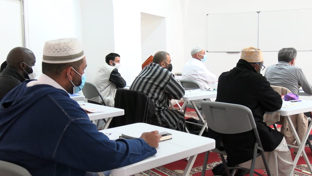 Imams en réunion dans une salle de conférence en France.