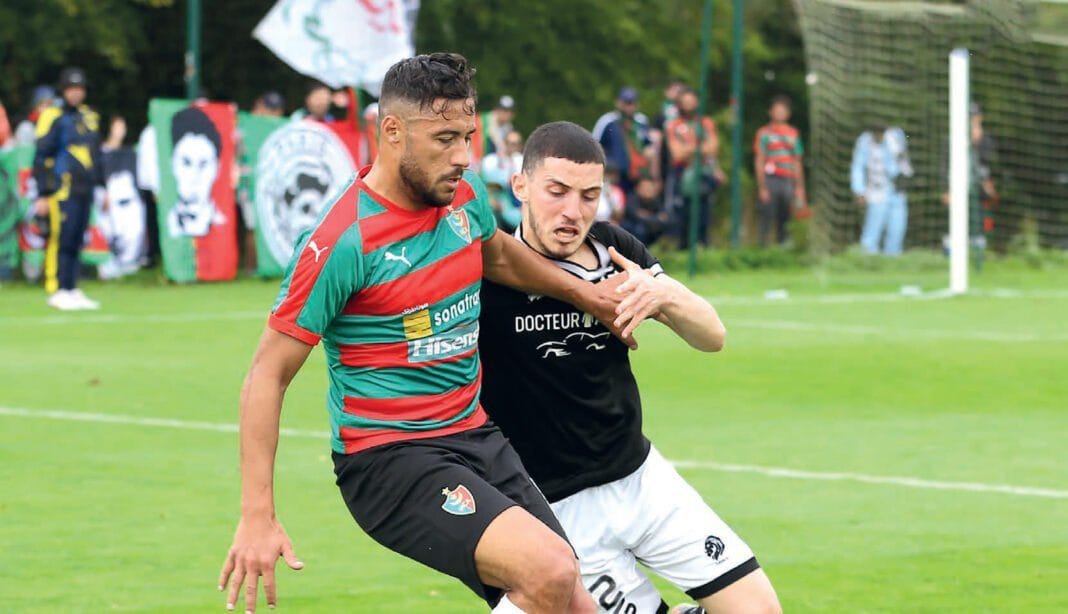 Deux joueurs de football en action lors d'un match en plein air.