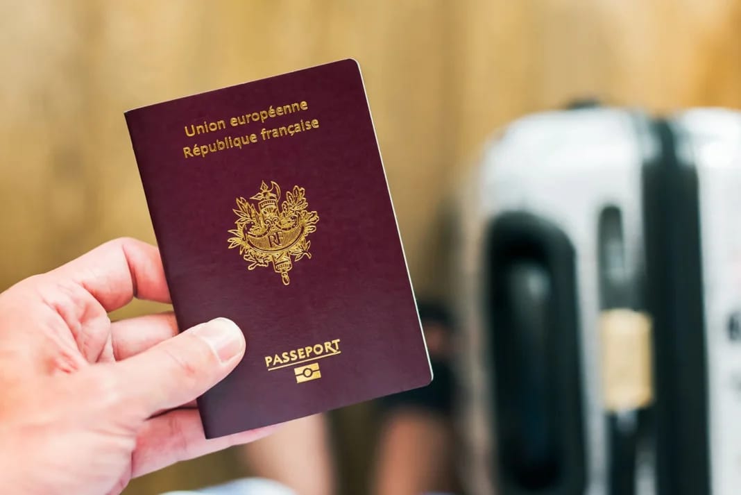 Passeport français dans une main, prêt pour la naturalisation.