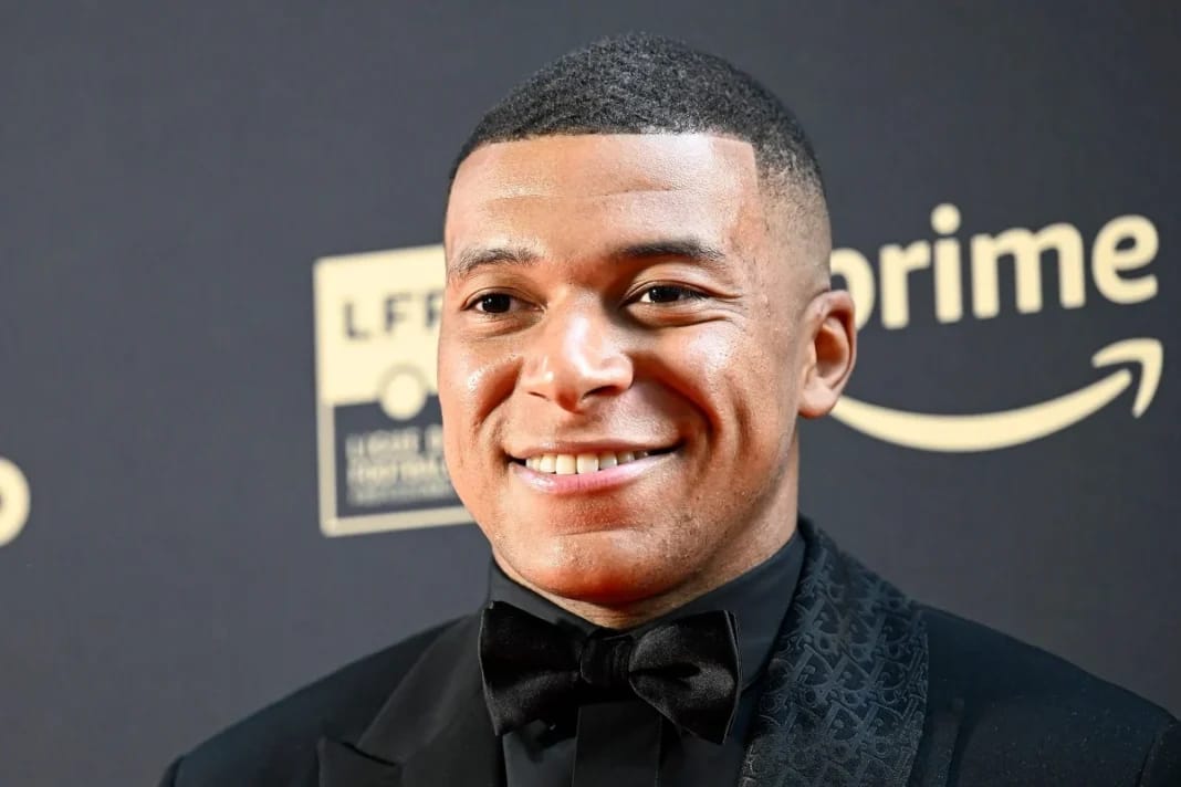 Algérie : Kylian Mbappé compte financer quatre projets Kylian Mbappe souriant en costume noir et nœud papillon.