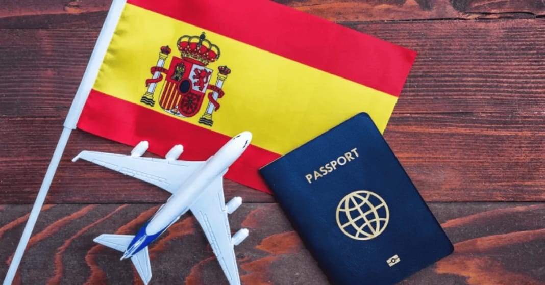 Drapeau espagnol, avion en plastique et passeport sur bois.