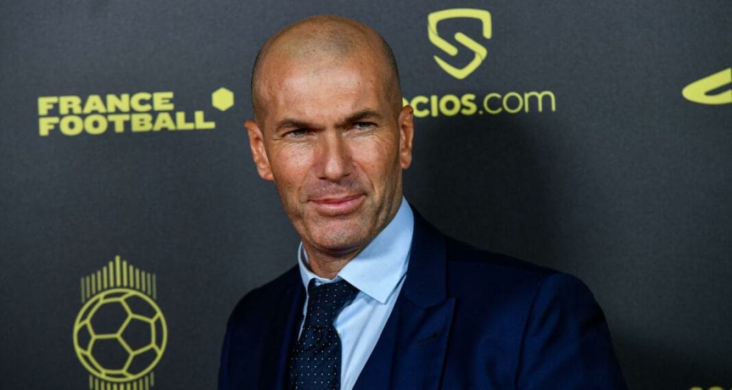 Zidane : Ses Inspirations, Son Héritage et Son Retour Imminent sur les Terrains Zinedine Zidane lors d'une conférence, visage concentré, fond de logo football et médias.