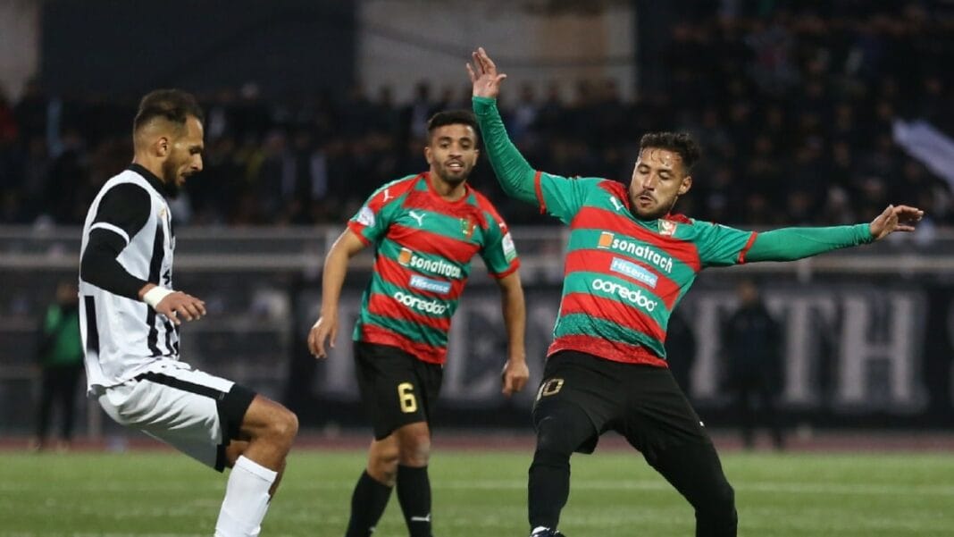Joueur algérien en action lors d'un match de football.