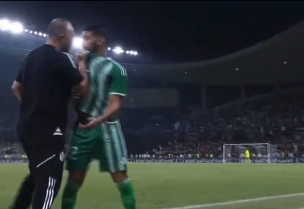 Said Benrahma et Belmadi en conversation sur le terrain de football.