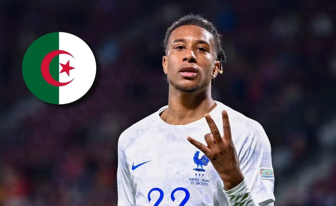 Michael Olise portant le maillot de l'équipe de France, faisant un geste de victoire.