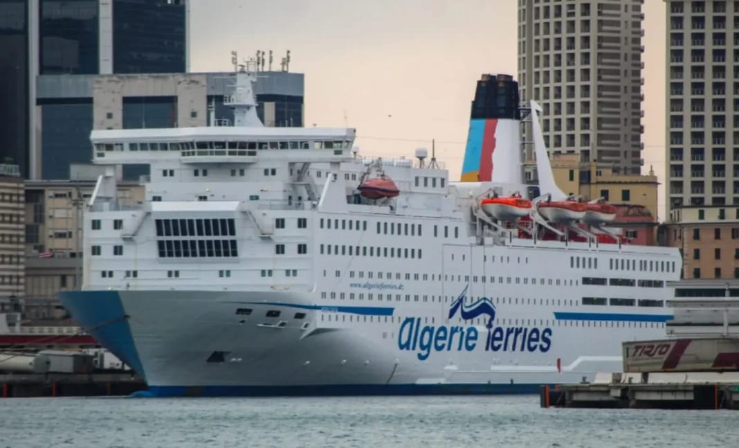 Ferry Algérie Ferries hors service en Espagne avec ville en arrière-plan.