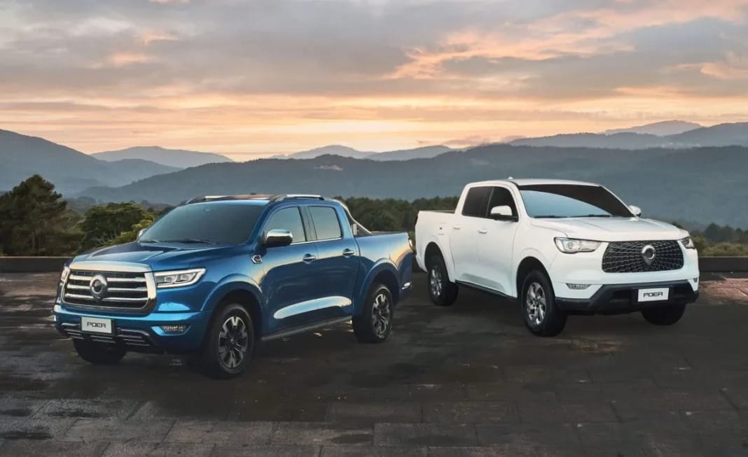 Deux pick-up Great Wall en plein air avec paysage montagneux au coucher du soleil.