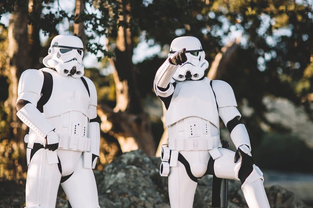Deux stormtroopers Star Wars en costume blanc dans un décor naturel.